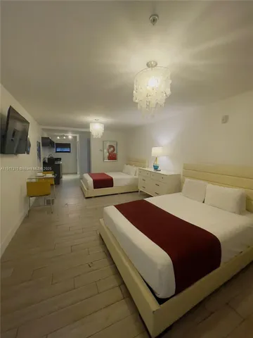 a spacious bedroom with a bed and a chandelier