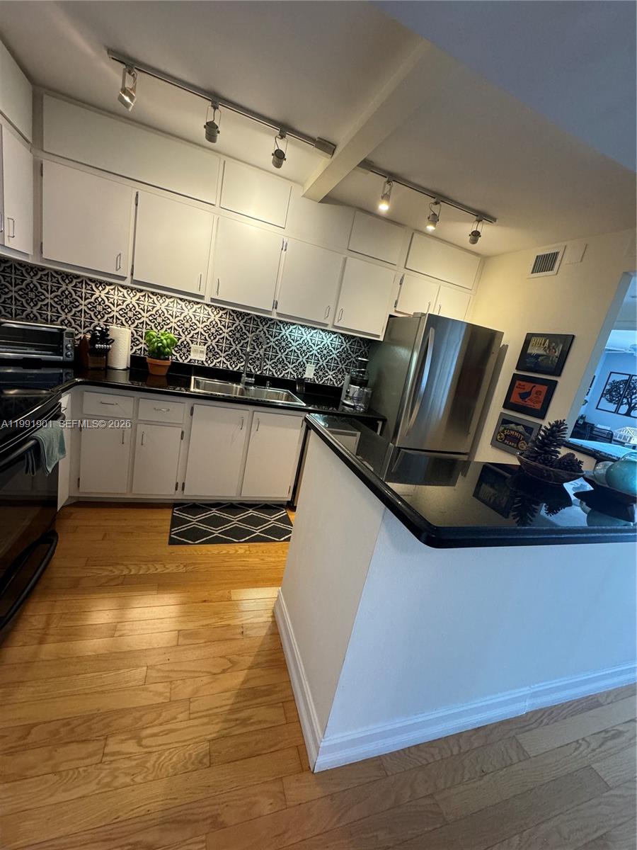 150 Southeast 25th Road, Unit 11L Miami, FL 33129 - Photo 9 of 11 a kitchen with stainless steel appliances granite countertop a sink a stove and cabinets