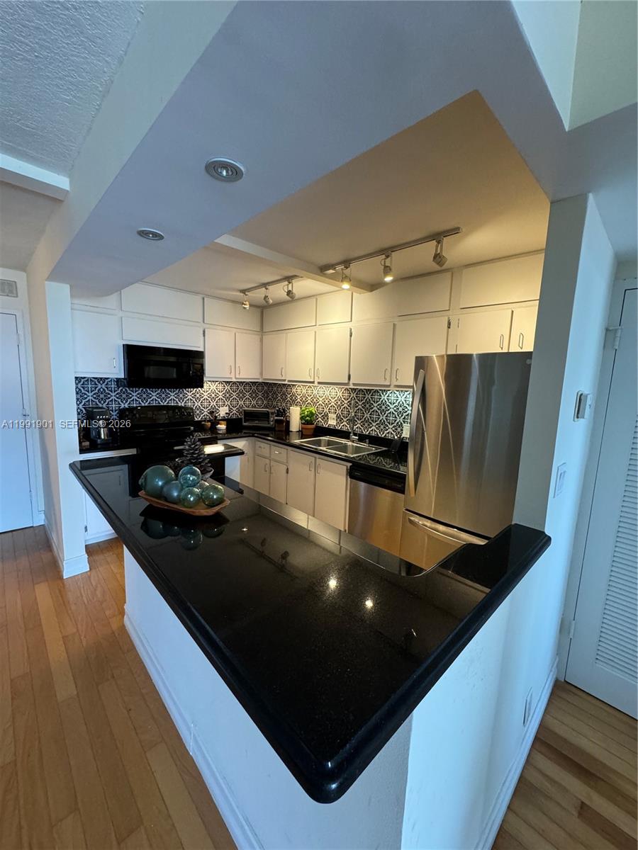 150 Southeast 25th Road, Unit 11L Miami, FL 33129 - Photo 10 of 11 a kitchen with stainless steel appliances granite countertop a sink a stove and a refrigerator