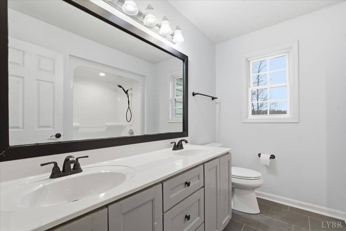 1329 Jeb Stuart Place Forest, VA 24551 - Photo 32 of 60 a bathroom with a toilet a double vanity sink and a mirror
