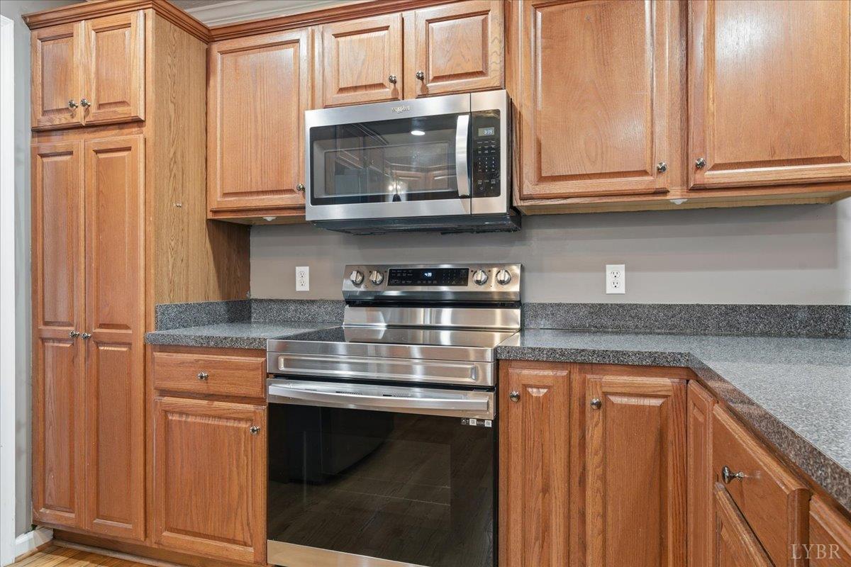 1329 Jeb Stuart Place Forest, VA 24551 - Photo 9 of 60 a kitchen with stainless steel appliances granite countertop a stove microwave and cabinets