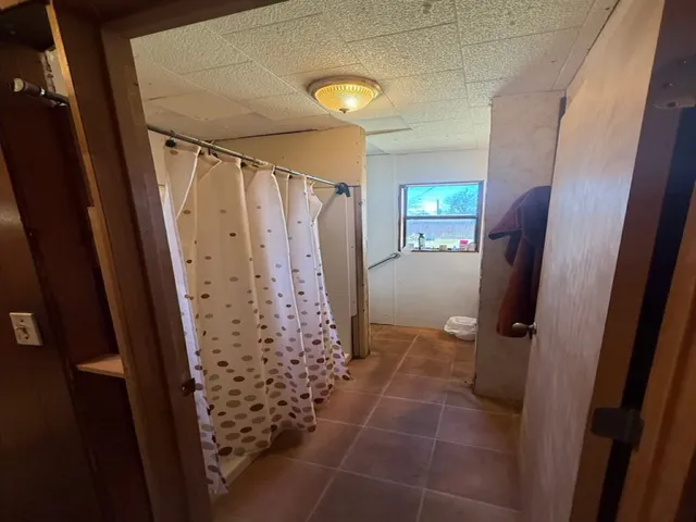 a view of a bathroom with shower and mirror