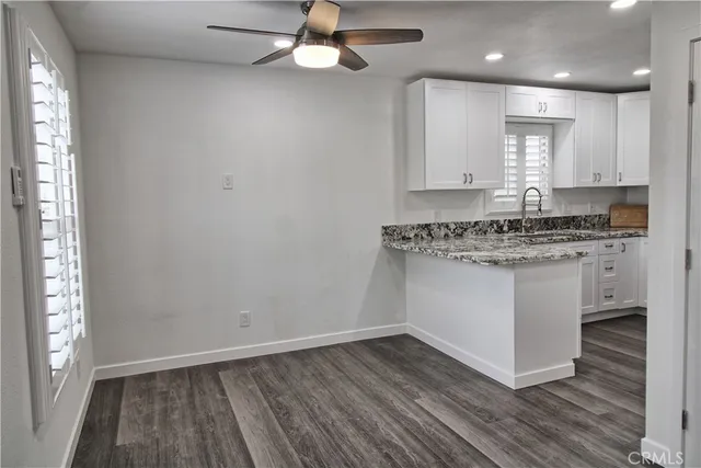 a kitchen with a sink cabinets and wooden floor
