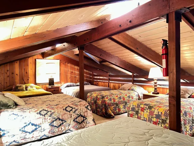 a bedroom with three beds and a large window