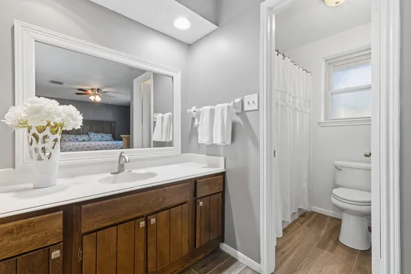 a bathroom with a granite countertop sink a toilet and a large mirror