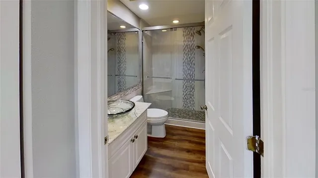 a bathroom with a granite countertop shower a toilet and a sink