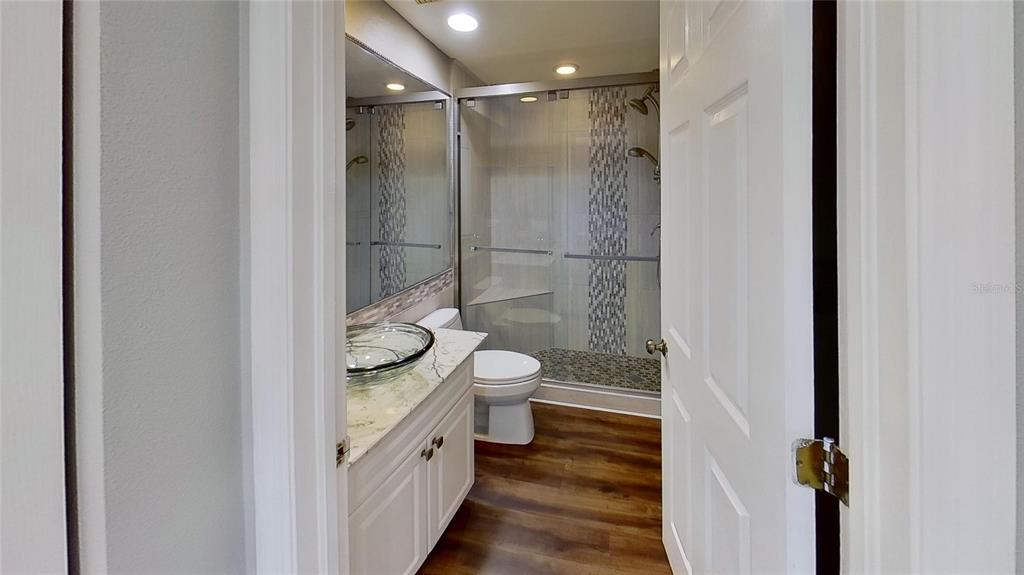 6495 Shoreline Drive, Unit 8104 St. Petersburg, FL 33708 - Photo 12 of 70 a bathroom with a granite countertop shower a toilet and a sink