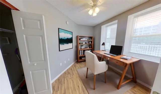 a view of a workspace with furniture and a window