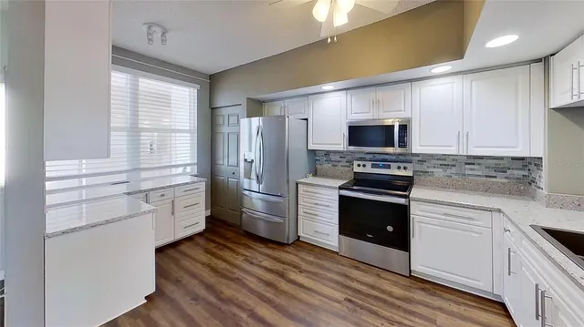 a kitchen with stainless steel appliances a stove a refrigerator and a sink