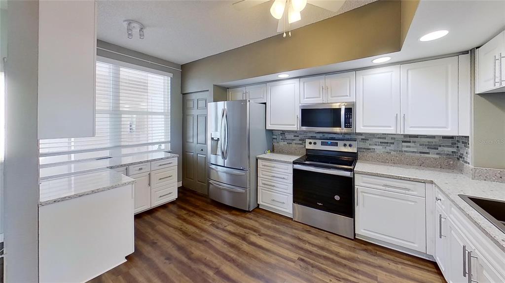 6495 Shoreline Drive, Unit 8104 St. Petersburg, FL 33708 - Photo 24 of 70 a kitchen with stainless steel appliances a stove a sink and a refrigerator