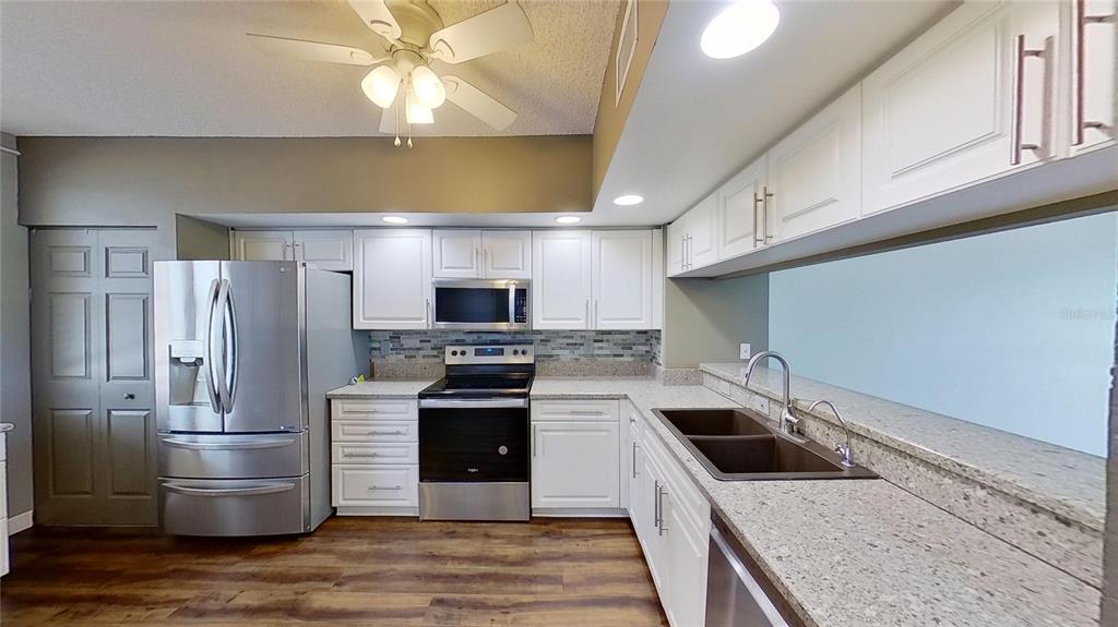 6495 Shoreline Drive, Unit 8104 St. Petersburg, FL 33708 - Photo 26 of 70 a kitchen with stainless steel appliances a stove a refrigerator and a sink