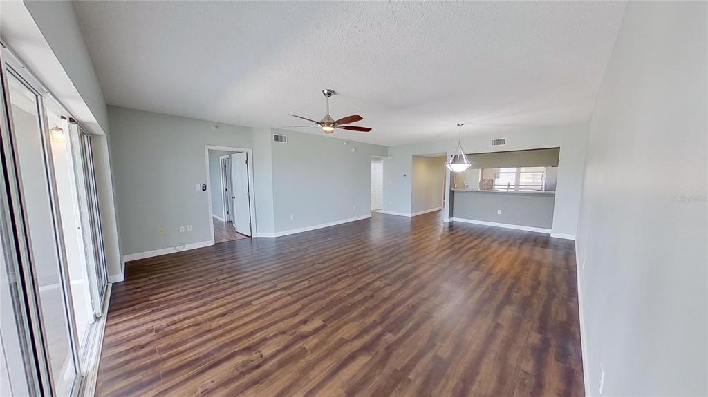 6495 Shoreline Drive, Unit 8104 St. Petersburg, FL 33708 - Photo 31 of 70 an empty room with wooden floor and windows