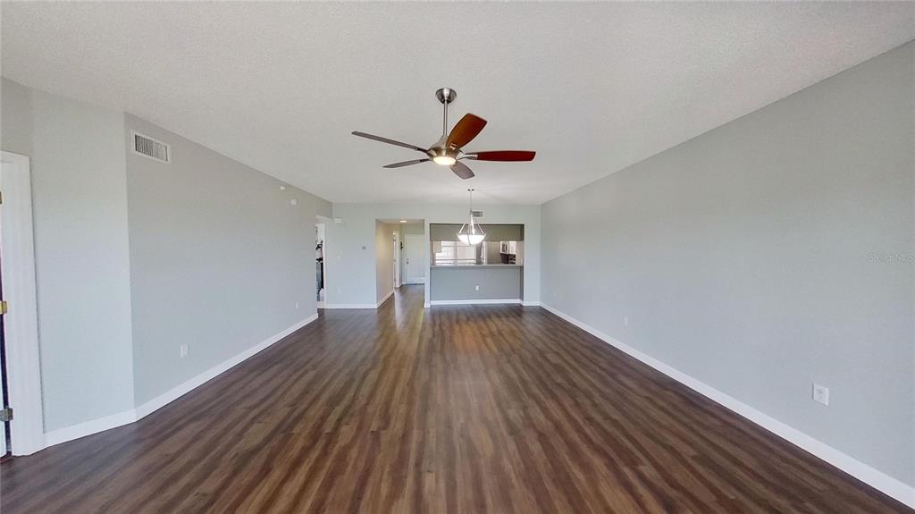 6495 Shoreline Drive, Unit 8104 St. Petersburg, FL 33708 - Photo 32 of 70 a view of empty room with wooden floor and ceiling fan
