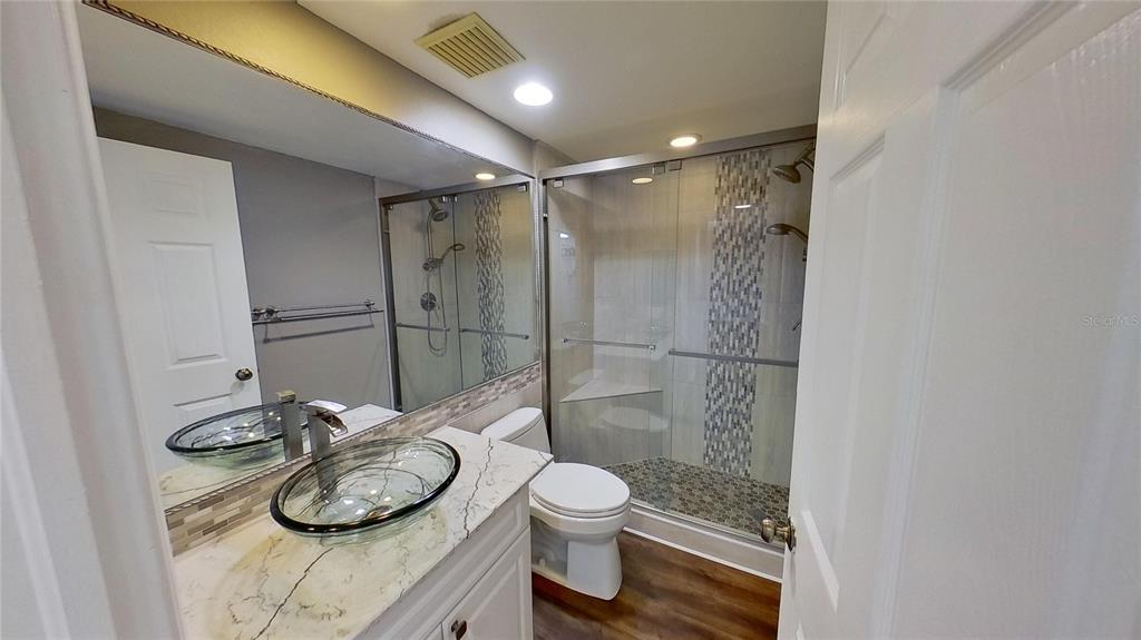 6495 Shoreline Drive, Unit 8104 St. Petersburg, FL 33708 - Photo 50 of 70 a bathroom with a granite countertop sink toilet and shower
