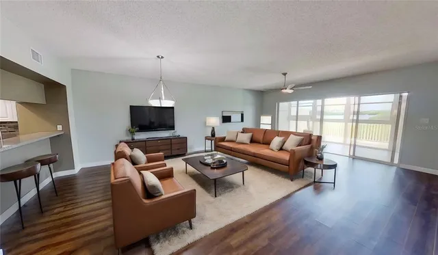 a living room with furniture a flat screen tv and a wooden floor