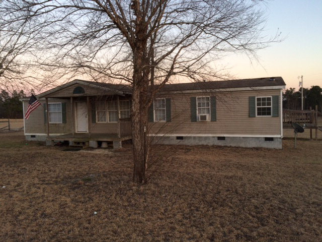 410 Beck Road Williston, SC 29853 - Photo 1 of 9 a backyard of a house with wooden fence and large trees