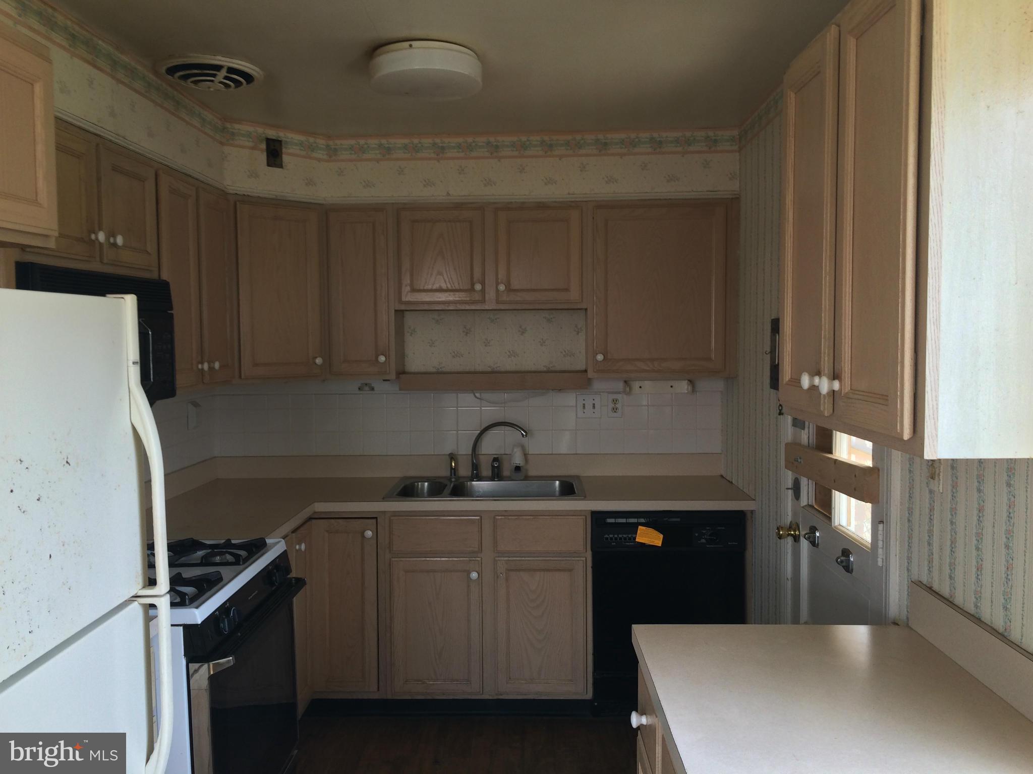 3704 Fairly Street Silver Spring, MD 20906 - Photo 6 of 24 a kitchen with a sink a refrigerator and cabinets