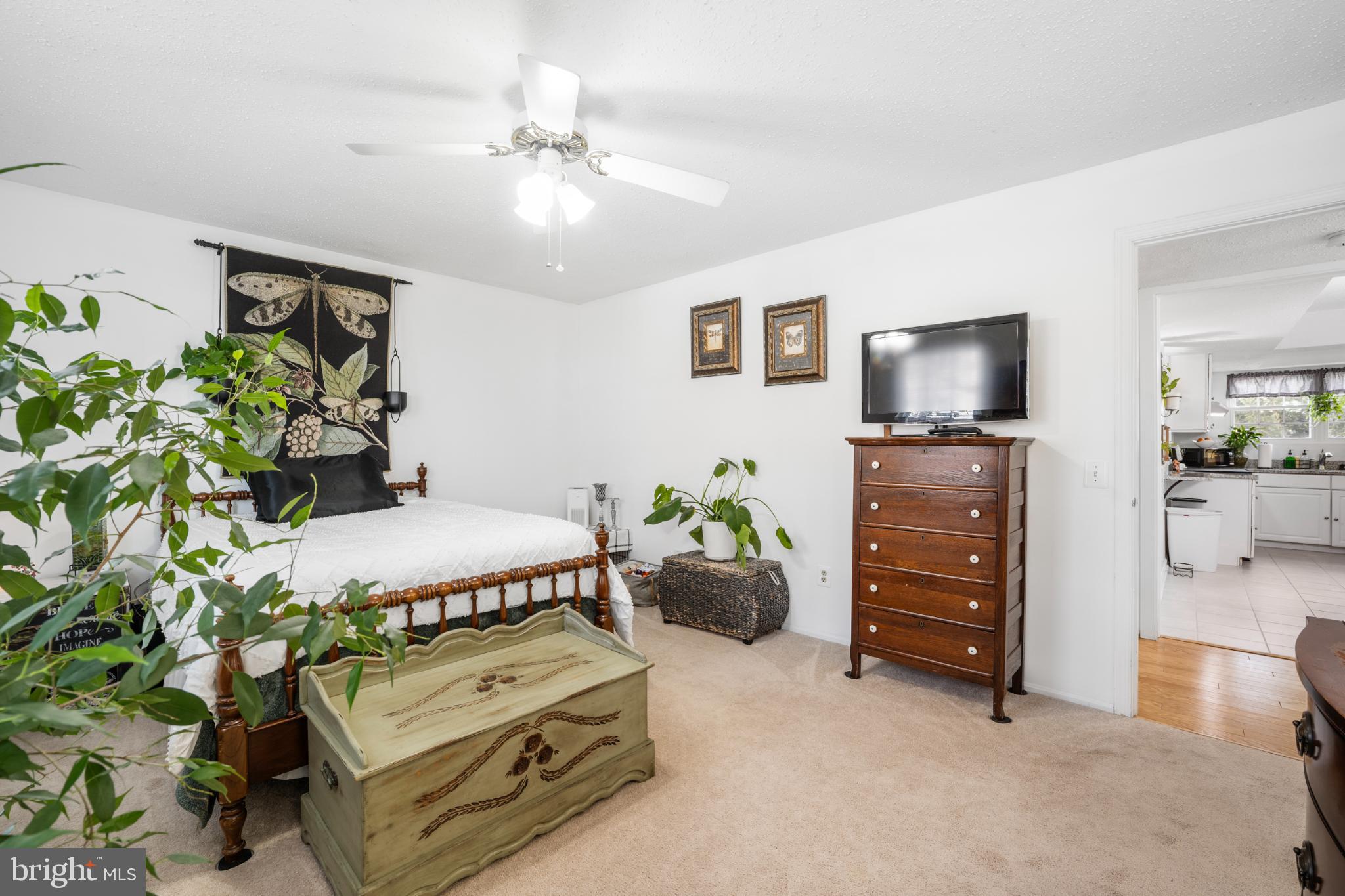 107 Fort Evans Road Southeast, Unit B Leesburg, VA 20176 - Photo 12 of 21 a spacious bedroom with a bed and a flat tv screen on dresser