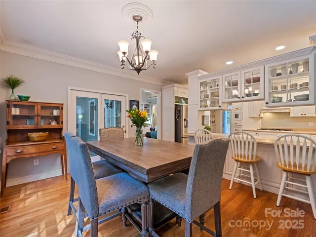 a view of a dining room with furniture a chandelier and wooden floor