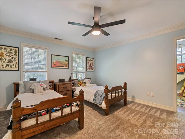 a spacious bedroom with two beds and painting on the wall