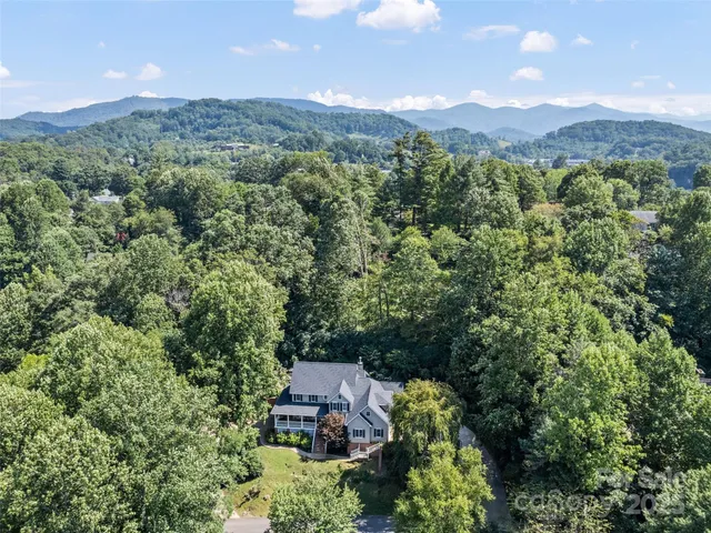an aerial view of a city with lots of residential buildings and mountain view in back