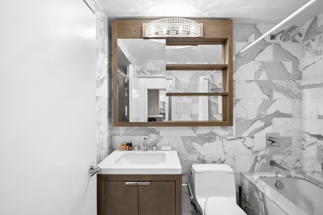 a bathroom with a sink toilet and mirror
