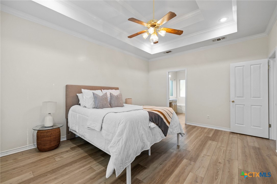 707 Livingston Court Temple, TX 76502 - Photo 18 of 36 a bedroom with a bed and a chandelier