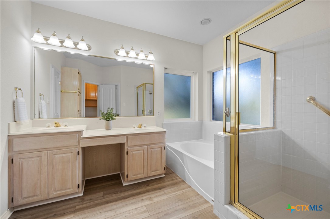 707 Livingston Court Temple, TX 76502 - Photo 23 of 36 a large bathroom with a double vanity sink a large mirror and a bathtub