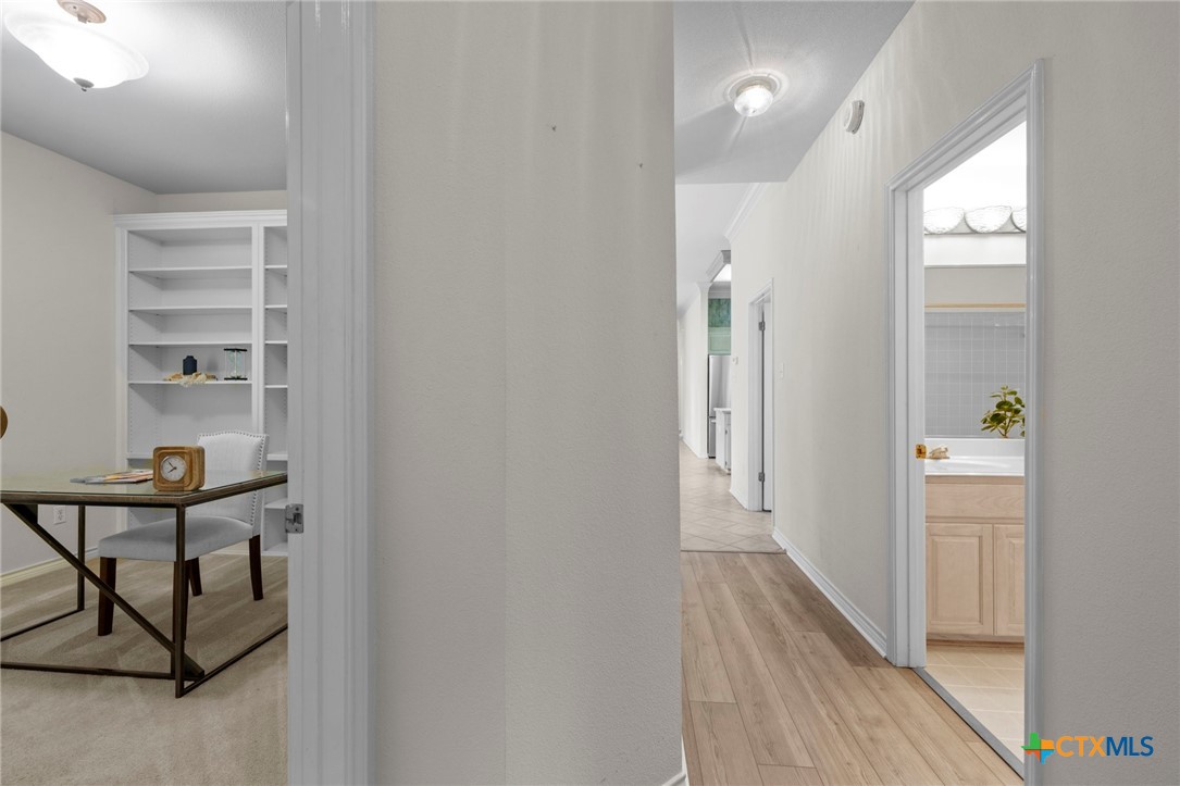 707 Livingston Court Temple, TX 76502 - Photo 26 of 36 a view of a hallway to a livingroom with wooden floor and windows