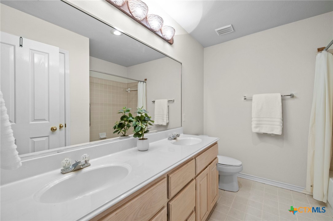 707 Livingston Court Temple, TX 76502 - Photo 28 of 36 a bathroom with a toilet sink and mirror