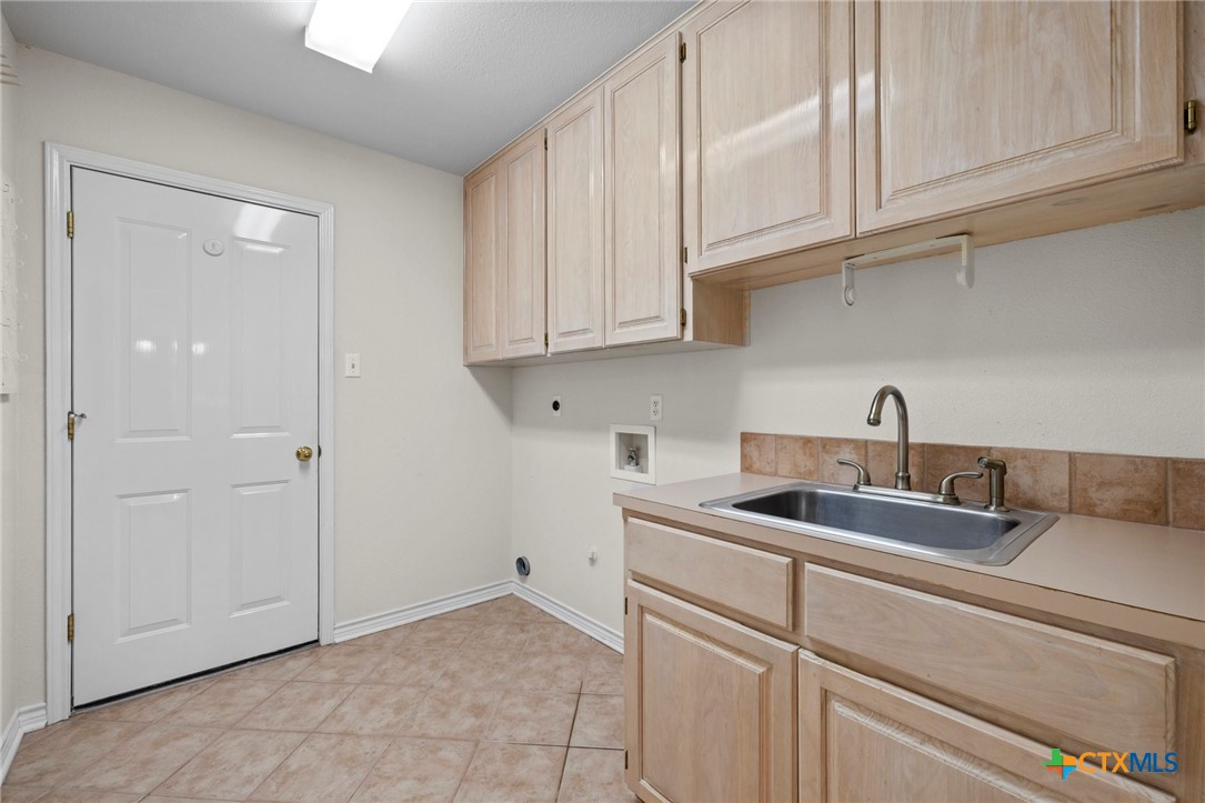 707 Livingston Court Temple, TX 76502 - Photo 30 of 36 a kitchen with white cabinets and a sink