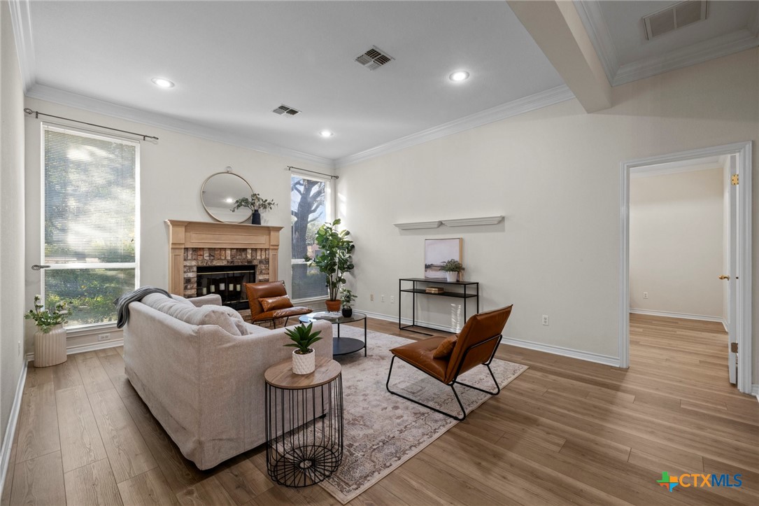 707 Livingston Court Temple, TX 76502 - Photo 8 of 36 a living room with furniture a fireplace and a large window