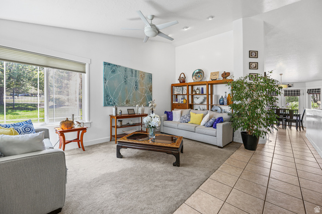 31 Village Square Road Centerville, UT 84014 - Photo 5 of 29 Bright living area featuring a large window, vaulted ceilings, a ceiling fan, and carpeted flooring