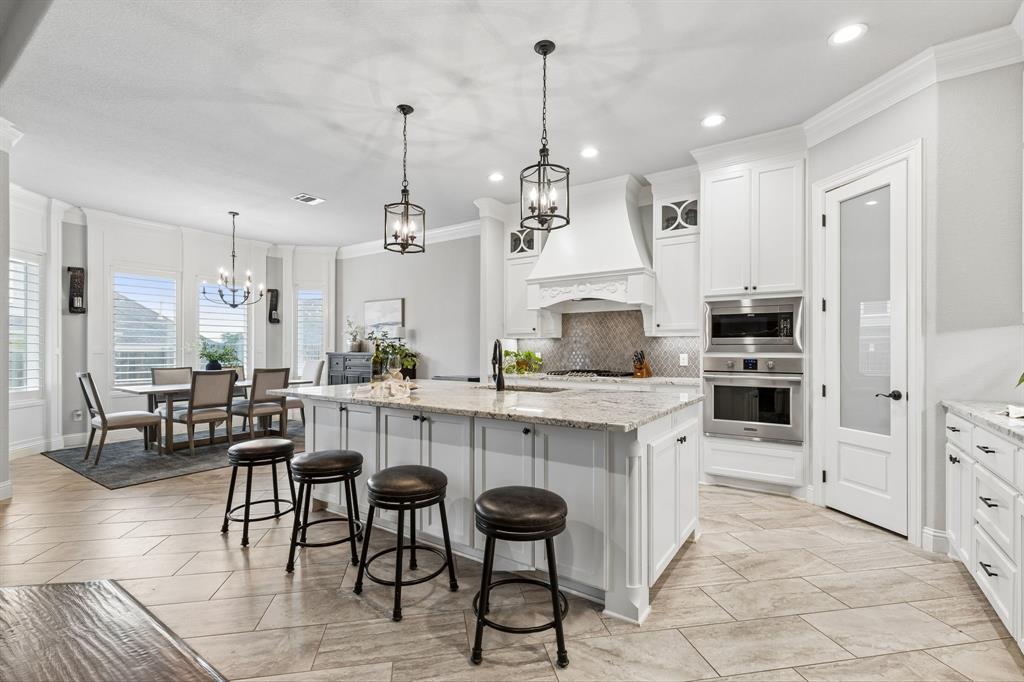 104 Ryder Court Hurst, TX 76053 - Photo 12 of 35 Gourmet Kitchen With Stainless Appliances, Decorative Vent Hood, And Large Island