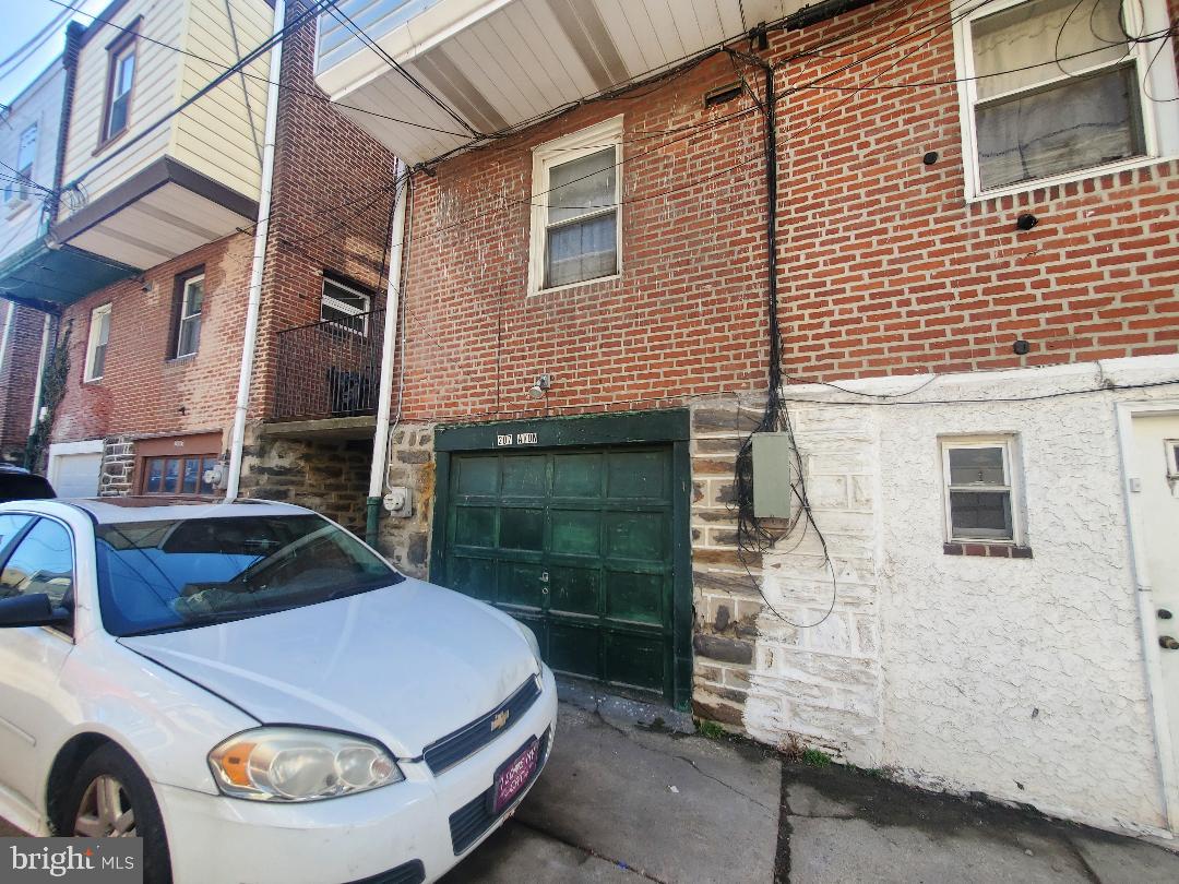 207 Avon Road Upper Darby, PA 19082 - Photo 27 of 29 a car parked in front of a brick house