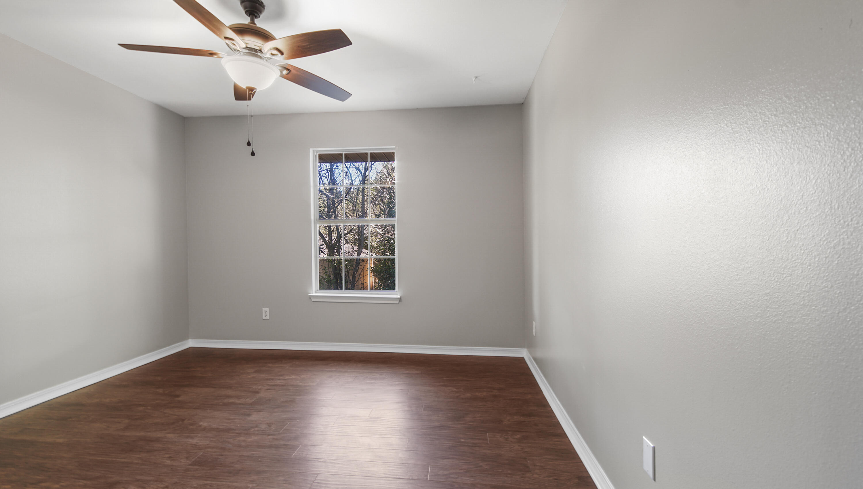 5200 Whitehurst Lane Crestview, FL 32536 - Photo 26 of 49 an empty room with wooden floor fan and windows