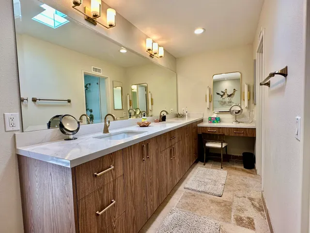 a en suite bathroom with a double vanity sink and a mirror