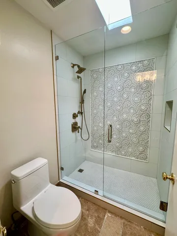 a white toilet next to a bathroom
