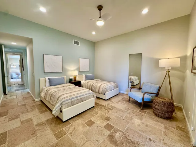 a spacious bedroom with a bed and a lamp