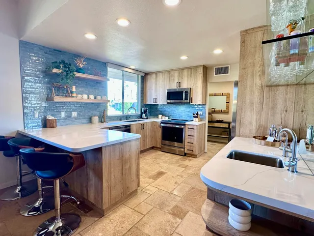 a kitchen with kitchen island a stove a sink a counter space and a dining table