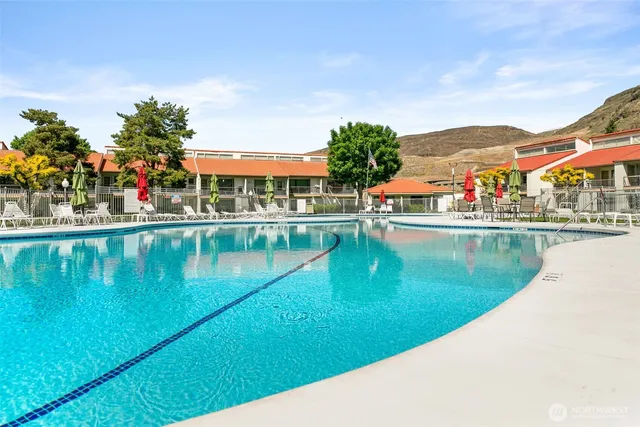 an aerial view of ocean and residential houses with outdoor space