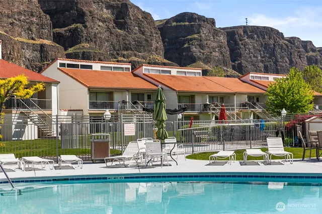 a view of house with swimming pool and outdoor seating