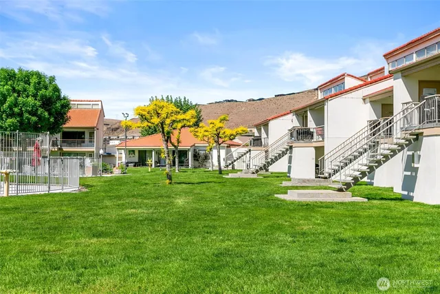 a view of house with a big yard and large trees