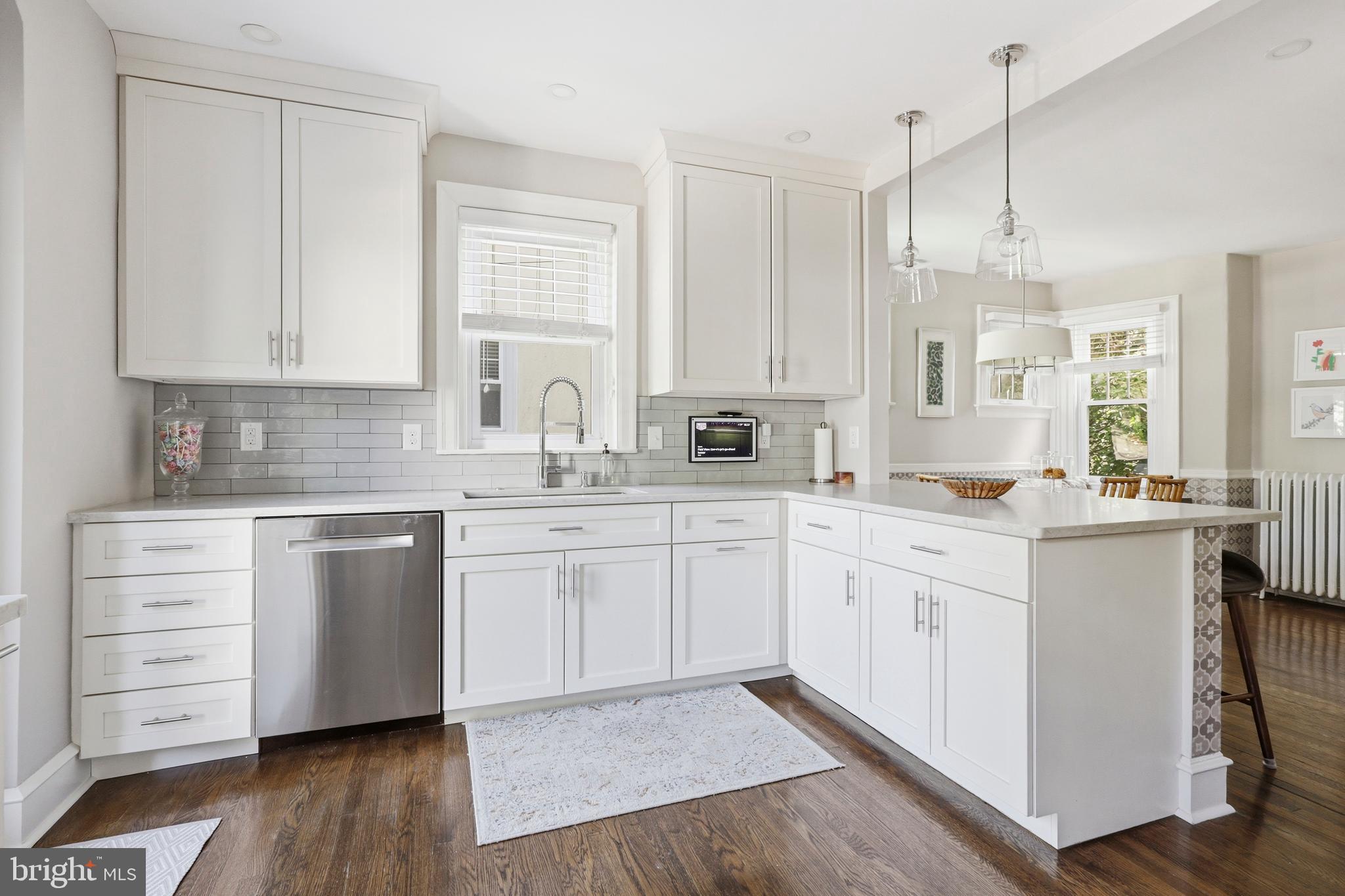 307 East Gravers Lane Philadelphia, PA 19118 - Photo 9 of 44 a kitchen with white cabinets appliances a sink and a window