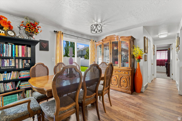 1025 Bristol Road Fruit Heights, UT 84037 - Photo 7 of 20 Open-concept dining area featuring wood-finish flooring, a contemporary ceiling light fixture, and sliding glass doors providing access to the backyard