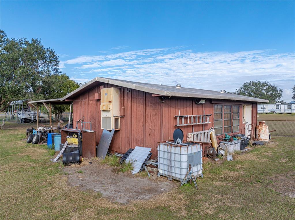 11404 Lithia Pinecrest Road Lithia, FL 33547 - Photo 53 of 63 a backyard of a house with barbeque oven table and chairs