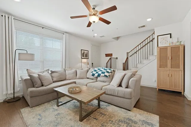a living room with furniture and a wooden floor