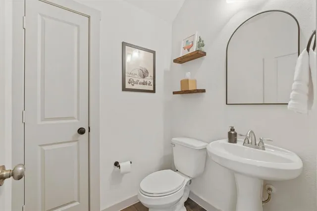 a bathroom with a toilet a sink and mirror