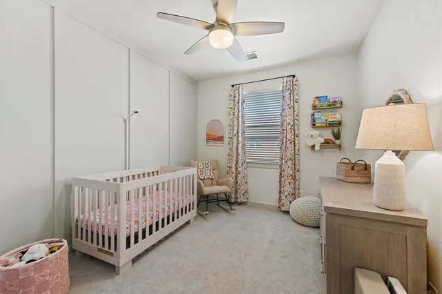 a bedroom with furniture and a chandelier fan