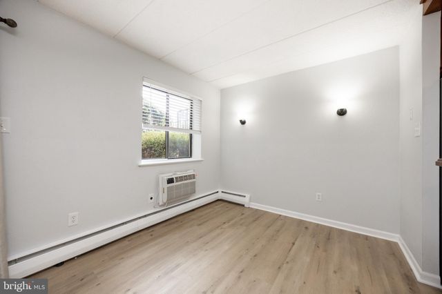 a kitchen with stainless steel appliances kitchen island granite countertop a refrigerator a stove and a sink with wooden floor